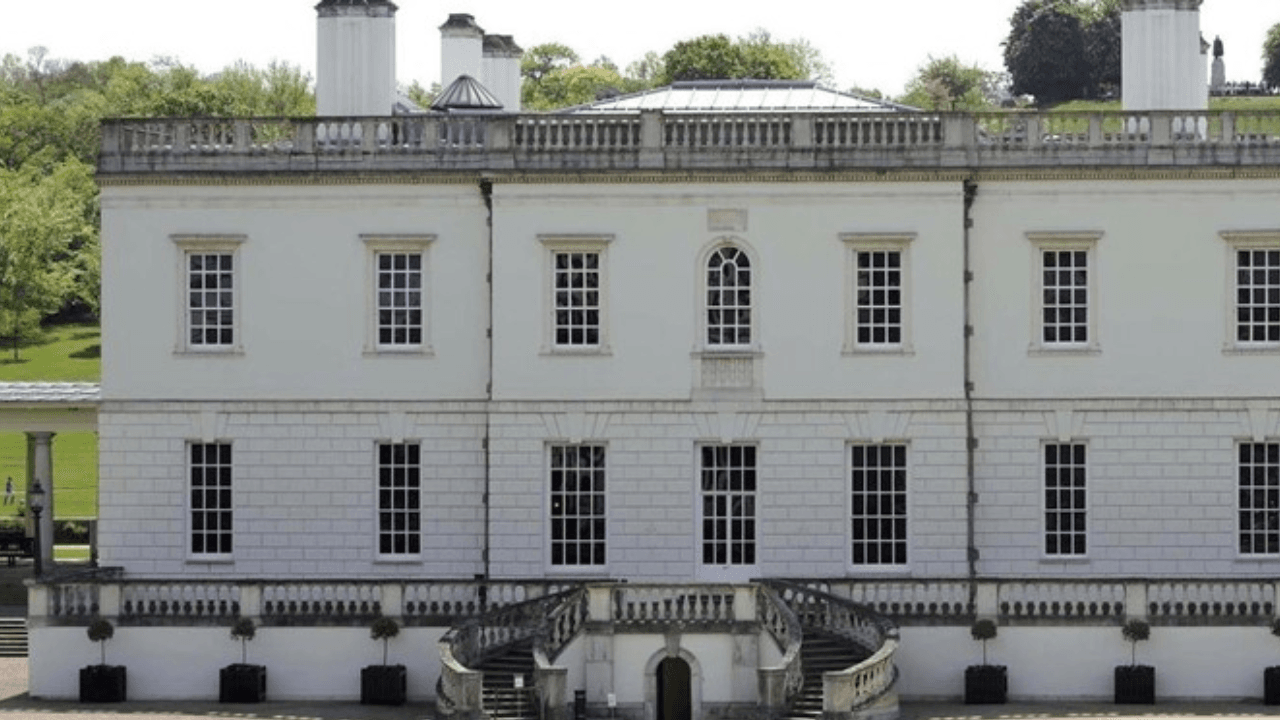 The exterior of Queen’s House, a historic white classical building with symmetrical windows and a grand entrance, set within Greenwich Park.