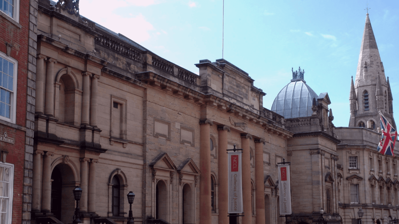 The exterior of the National Justice Museum, a historic stone building with large arched windows and an entrance framed by columns.